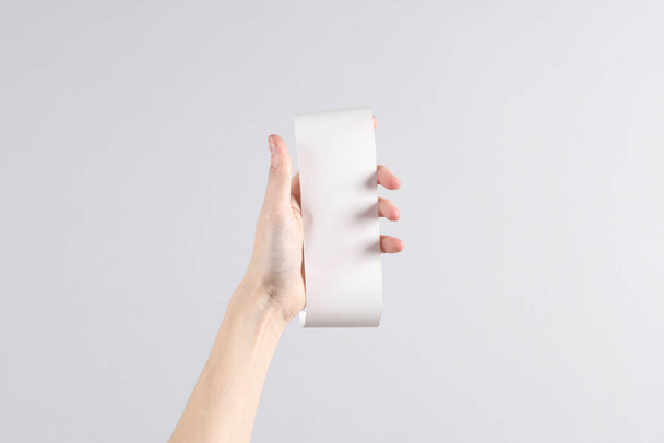 Ręka kobiety trzymać biały pusty rachunek makieta na szarym tle. Szablon do projektowania. Miejsca na tekst - Zdjęcie, obraz