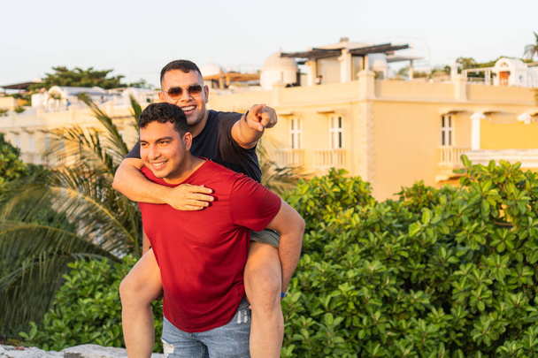 Due uomini allegri in abbigliamento casual godendo di un momento giocoso su un tetto soleggiato. - Foto, immagini