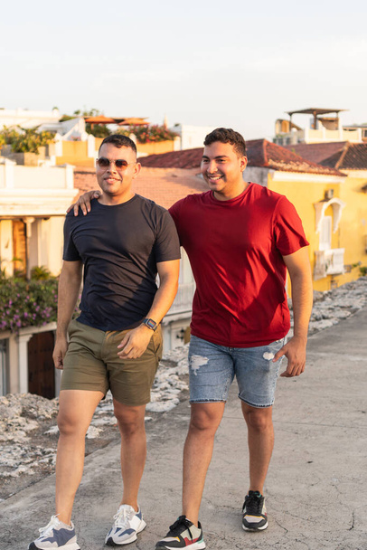 Due uomini che camminano e si godono una conversazione su un tetto al tramonto - Foto, immagini