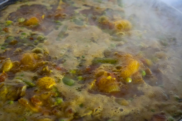 Close-up van kokende bouillon bij de bereiding van een gerecht van de Spaanse gastronomie, a Paella - Foto, afbeelding