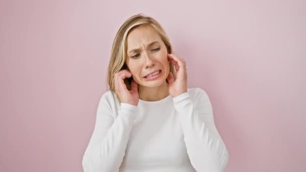 Femme blonde fatiguée en rose couvrant les oreilles d'un bruit fort - sourde à la migraine induisant des sons? - Séquence, vidéo