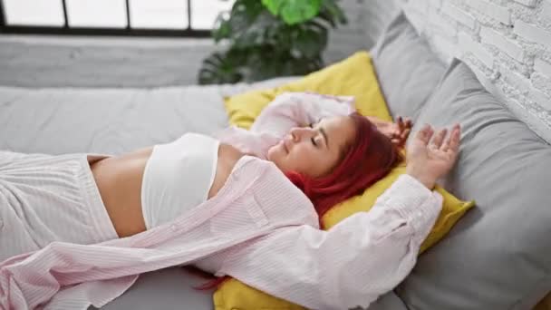 Sıcak bir battaniyeye sarılmış güzel, kızıl saçlı bir kadın, yatak odasında dinlenirken kendine güveni ve pozitifliği yayıyor. Sabahları ışıl ışıl gülümsüyor.. - Video, Çekim