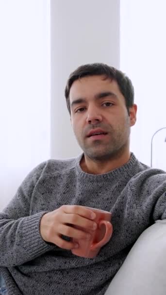 Hispanic man talking to camera sitting on sofa. Person giving advice. - Footage, Video