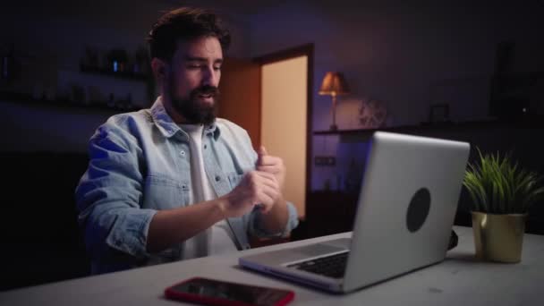 Entuzjastycznie atrakcyjny biały mężczyzna korzystający z laptopa i rozpoczynający pracę w biurze. Wolny strzelec biały mężczyzna koncentruje się nad rozwojem nowego cyfrowego projektu pracy. Młodzi ludzie pracujący w nocy online. - Materiał filmowy, wideo