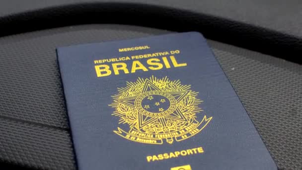 Бразильский паспорт расположен на приборной панели автомобиля, готовый к новым путешествиям. Готов к путешествию: бразильский паспорт виден на приборной панели автомобиля. - Кадры, видео