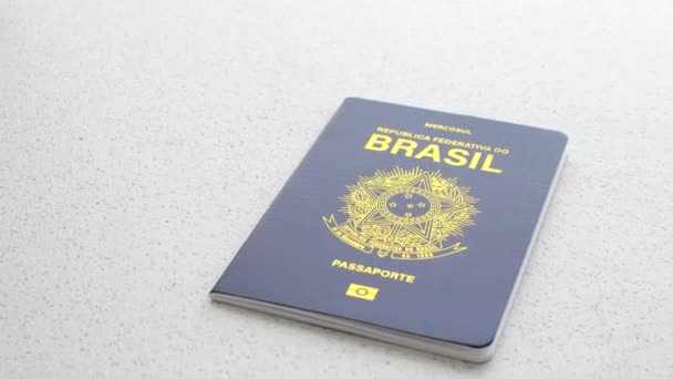 Бразильський паспорт на білій поверхні, що представляє національну ідентичність простим і елегантним способом. - Кадри, відео