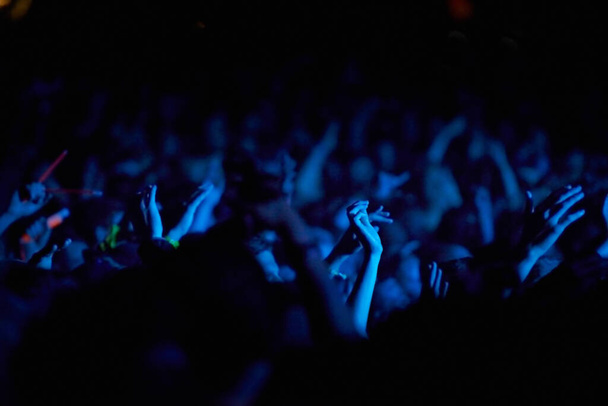 Konzert, Hände und Publikum für Musik mit Blaulicht, Neon- und Nachtfestival, Konzert oder psychedelische Party. Menschenmenge mit erhobenen Armen mit Nightlife und Rave oder Techno-Event zum Neujahrsfest. - Foto, Bild