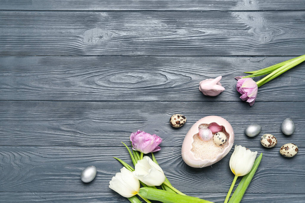 Paskalya bıldırcın yumurtaları, lale çiçekleri ve gri ahşap arka planda tavşanlı kompozisyon - Fotoğraf, Görsel
