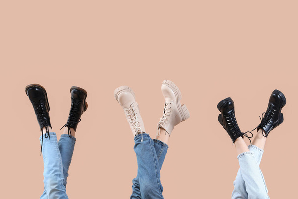 Kobiece nogi w różnych butach na beżowym tle - Zdjęcie, obraz