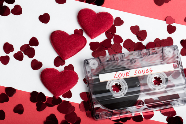 Audio cassette tape on red backgound with fabric heart - Photo, Image