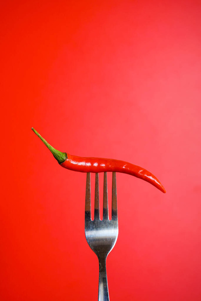rote Paprika auf einer roten Gabel - Foto, Bild
