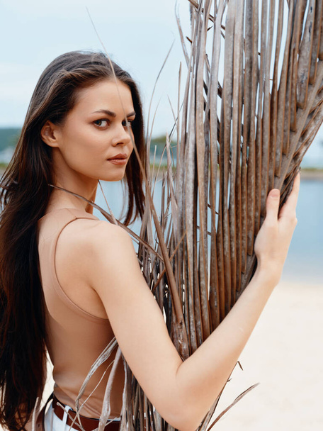 Belleza, Mujer, Retrato: Joven, Atractiva dama caucásica con el pelo morena posando en la playa, Relajándose junto al mar en un lindo traje de baño azul. - Foto, Imagen