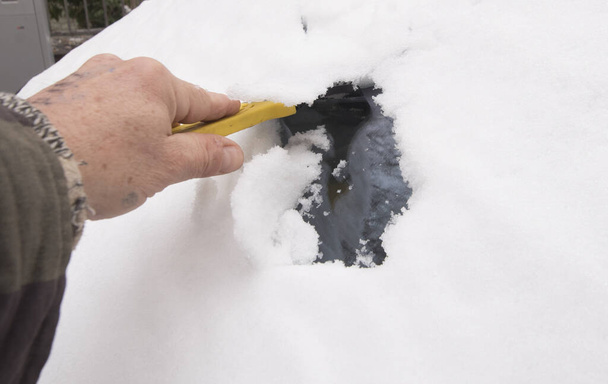 rimozione della neve dall'auto, pulizia della neve in una giornata invernale - Foto, immagini