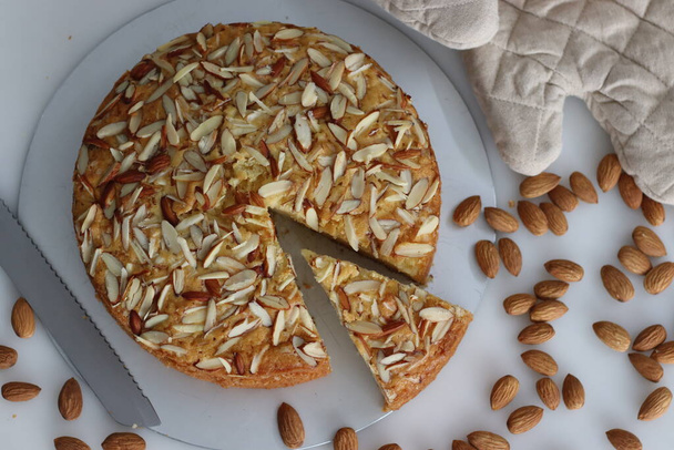 Sliced almond buttermilk cake. A delicious cake adorned with a generous sprinkle of chopped almonds, perfect for tea time. Easy-to-make and visually appealing. Tempting treat for any occasion - Photo, Image
