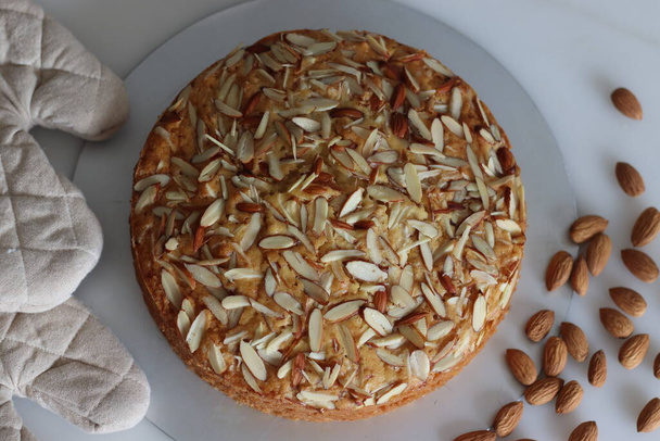 Almond buttermilk cake. A delicious cake adorned with a generous sprinkle of chopped almonds, perfect for tea time. Easy-to-make and visually appealing. Tempting treat for any occasion - Photo, Image