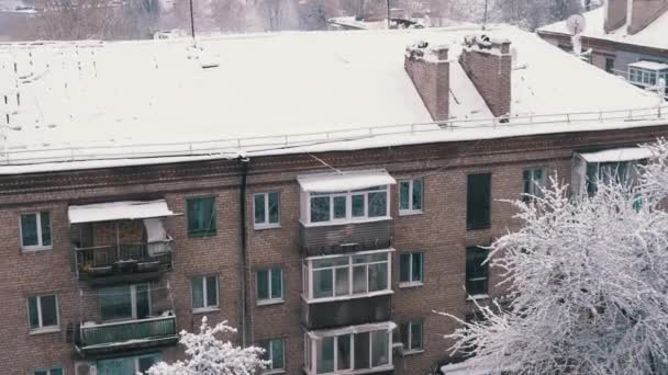 Vistas al patio de las cubiertas de nieve de los antiguos edificios residenciales. Vista superior, ventana. Edificios de ladrillo de varios pisos con balcones en la nieve. Panorama. Clima nublado. Paisaje invernal. Ciudad vieja. - Imágenes, Vídeo