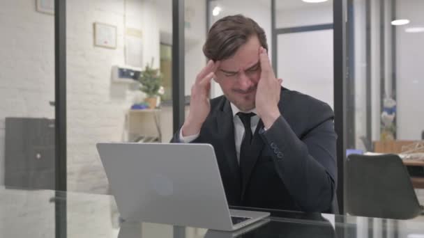 Geschäftsmann mittleren Alters mit Migräne im Büro - Filmmaterial, Video