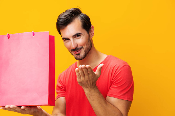 Мужчина пакет праздничной продажи скидка купить сувенирный магазин сумка представить клиенту сюрприз покупки моды образ жизни желтый - Фото, изображение
