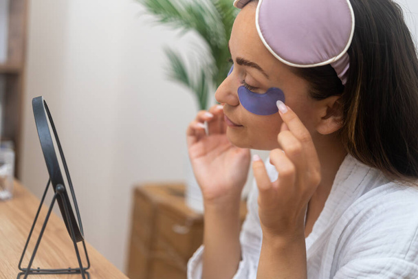 Radiant Skin: A beauty, with flawless and hydrated skin, uses hydrogel eye patches to banish dark circles for a fresh, youthful look.  - Photo, Image