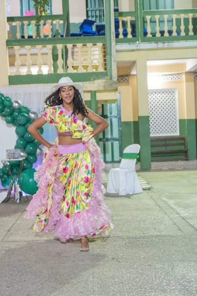 Magabiztos női táncos virágos Cumbia ruhában és Panama kalap áll egy kulturális ünnepségen. - Fotó, kép