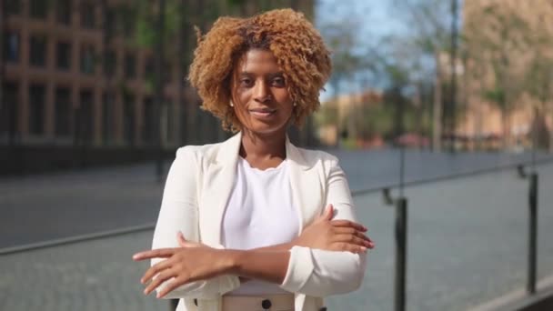 Video of a smiling african businesswoman crossing arms in the street - Footage, Video