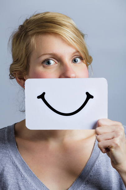 Ευτυχισμένος πορτρέτο του κάποιος που κατέχουν ένα χαμογελαστό πίνακας διαθέσεων - Φωτογραφία, εικόνα
