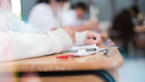 Sınav kağıtlarını okuyan ve alan öğrencilerin el kapaklarını kapatın sınıfta stres ile cevap verin - Fotoğraf, Görsel
