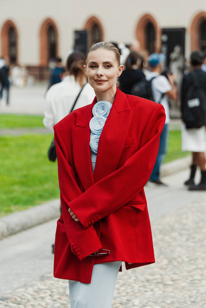 Ένας επισκέπτης φοράει κόκκινο υπερμεγέθης σακάκι κοστούμι έξω από Alberta Ferretti δείχνουν κατά τη διάρκεια Milan εβδομάδα μόδας Γυναικεία ενδύματα Άνοιξη / Καλοκαίρι 2024. - Φωτογραφία, εικόνα