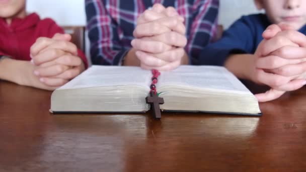 jeune mère avec ses fils priant avec la Bible et le crucifix - Séquence, vidéo