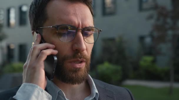 Close-up Kavkazský podnikatel naštvaný muž muž podnikatel zaměstnavatel mluví telefon mimo nepříjemný obchodní konverzace mluvit mobilní telefon připojení diskutovat problémy s klientem ve městě venku - Záběry, video