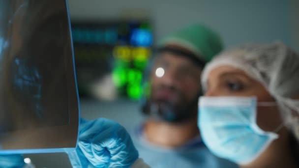 Medizinisches Team untersucht Röntgenbild im Operationssaal. - Filmmaterial, Video