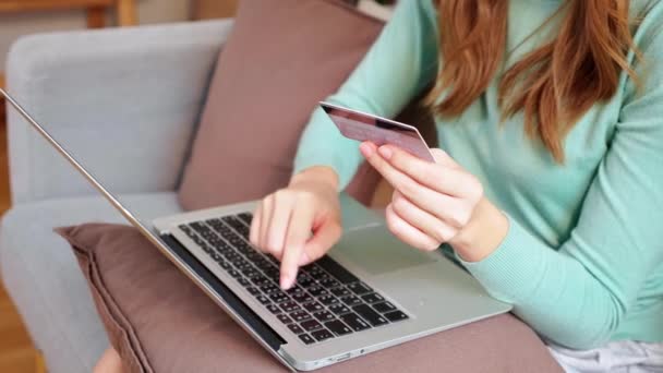 Nuori aasialainen nainen istuu sohvalla kannettavan tietokoneen ostoksia verkossa luottokortilla ostaa Internetiin, naisten maksu liiketoiminnan sohvalla, osto ja maksu, liiketoiminnan ja elämäntavat. - Materiaali, video