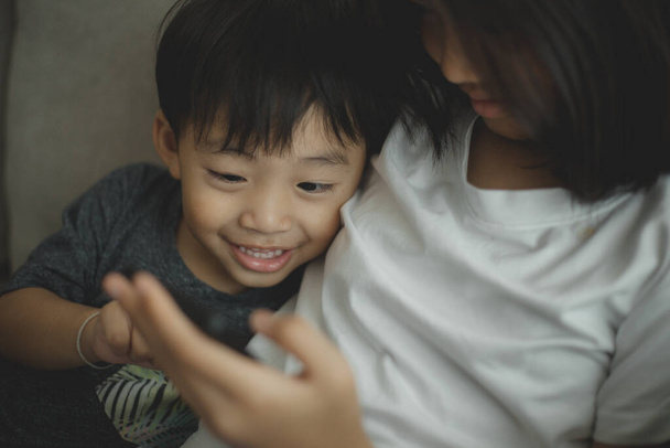 Les petites filles et les garçons regardent le téléphone et sourient. Ils tiennent un smartphone regarder des vidéos, apprendre, jouer à des jeux, et parler en ligne. Internet pour les enfants. Contrôle parental - Photo, image