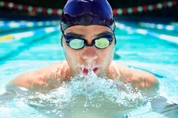 Athlete man, swimming pool and sport with splash, speed or exercise for wellness, health or fitness. Swimmer, closeup and person in water for training, contest or workout with goggles in summer games. - Photo, Image