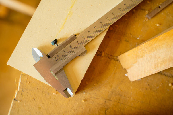 Primo piano di una pinza appoggiata su un tavolo nel laboratorio di un falegname - Foto, immagini