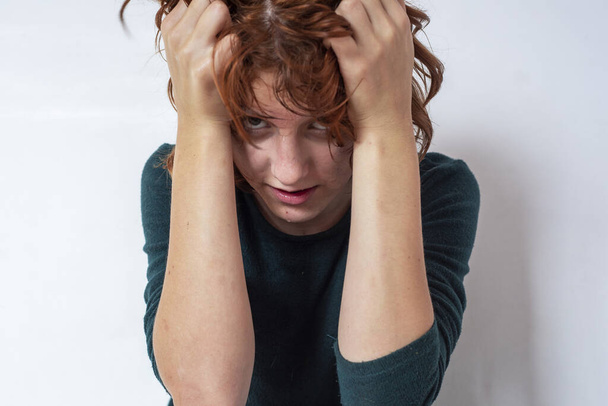 Μια έφηβη με κόκκινα μαλλιά κλαίει στο δωμάτιό της. Διαχείριση συναισθημάτων - Φωτογραφία, εικόνα