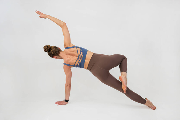 Mujer joven deportiva hacer ejercicio de yoga relajante aislado sobre fondo blanco. Estilo de vida saludable - Foto, imagen