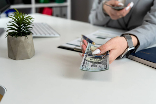 Kadın finans muhasebecisi, ofis işyerindeki kar, finans grafiği ve grafiğini dolar olarak sayar. Bütçe kavramı - Fotoğraf, Görsel
