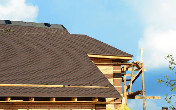 Közelkép egy befejezetlen tetőszerkezet aszfaltozott tetőzsindely telepítés a gerincen a tető és tetőfedő homlokzatok és soffit eltávolított.  - Fotó, kép