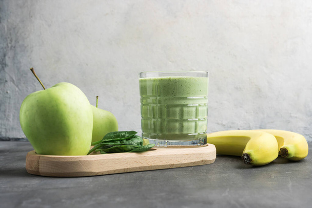 Frullato verde disintossicante in un bicchiere, bevanda vegetariana mista a base di foglie di spinaci, mela e banana, concetto di alimentazione sana. - Foto, immagini