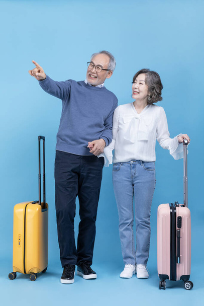 A senior standing with a travel suitcase - Fotó, kép