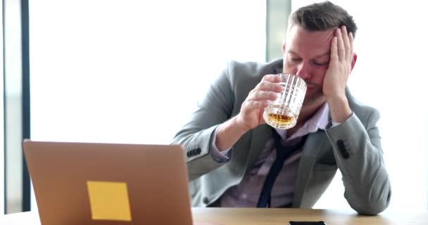 П'яний сумний бізнесмен тримає склянку з алкоголем на робочому місці. Емоційний стрес депресія і алкоголізм на роботі
 - Кадри, відео