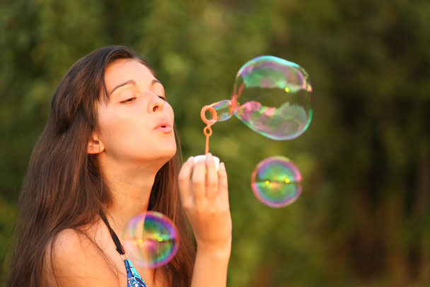 Pretty woman inflating soap-bubbles - Foto, Imagem