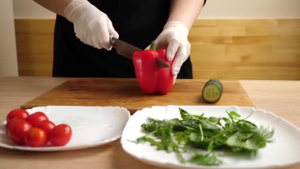 Красный перец нарезается для приготовления овощного салата. Подготовка овощного салата - Кадры, видео