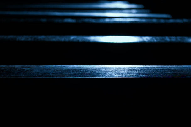 Ξύλινα παγκάκια με αντανάκλαση στον ήλιο στη σκοτεινή αίθουσα της εκκλησίας - Φωτογραφία, εικόνα