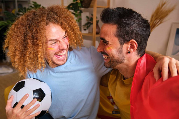 Νέοι άνδρες φίλοι γιορτάζουν τη νίκη της Ισπανίας στο Παγκόσμιο Κύπελλο ποδοσφαίρου. - Φωτογραφία, εικόνα