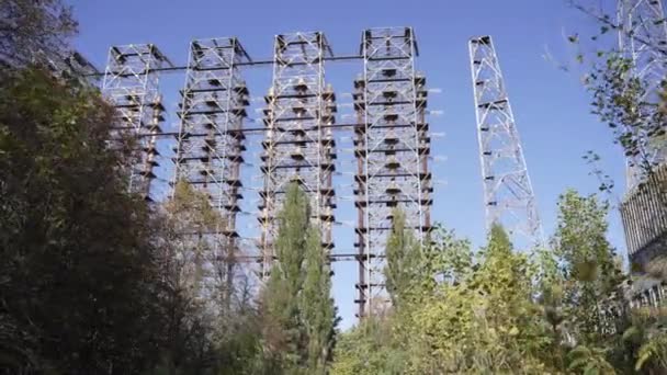 Zoom in door bomen van Duga radar systeem in verlaten militaire basis in Tsjernobyl Exclusion Zone, Oekraïne. Hoge kwaliteit 4k beeldmateriaal - Video