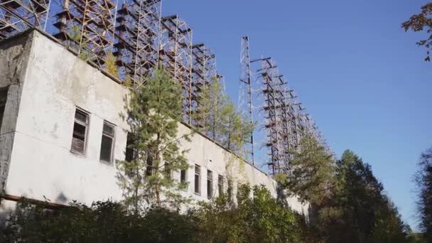 Widok systemu radarowego Duga horizon przez opuszczony budynek w Czarnobylu, Ukraina  - Materiał filmowy, wideo