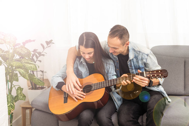 smiling father showing daughter how to play barre chord. High quality photo - Photo, Image