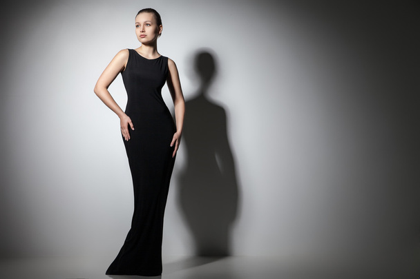 エレガントな黒のドレスでポーズ美しい女性モデル - 写真・画像